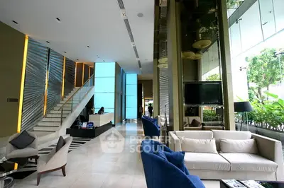 Luxurious modern living room with elegant furniture and large windows overlooking greenery.