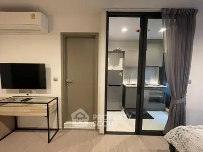 Modern apartment interior with sleek kitchen and cozy living area, featuring contemporary furniture and appliances.