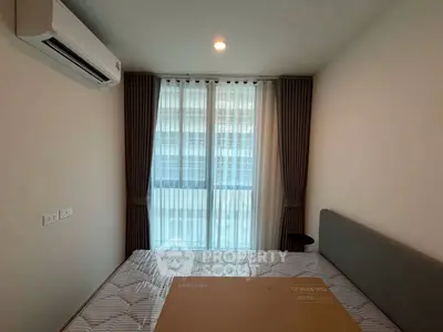 Cozy bedroom with air conditioning and large window for natural light