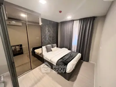 Modern bedroom with sleek design, mirrored wardrobe, and cozy bedding