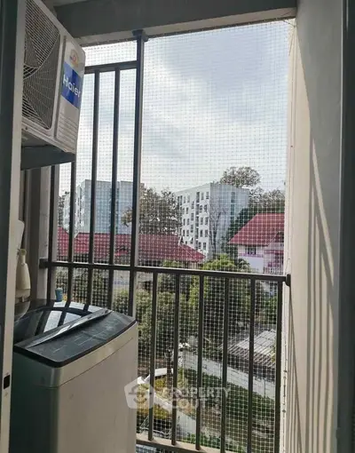 Charming balcony with washing machine and scenic view of modern residential buildings.