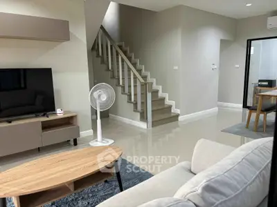 Modern living room with sleek staircase and stylish furniture in a contemporary home.