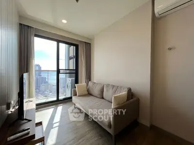 Modern living room with city view and cozy sofa in high-rise apartment.