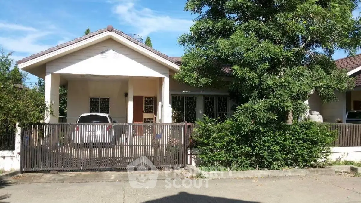 Charming suburban house with lush greenery and secure gated driveway