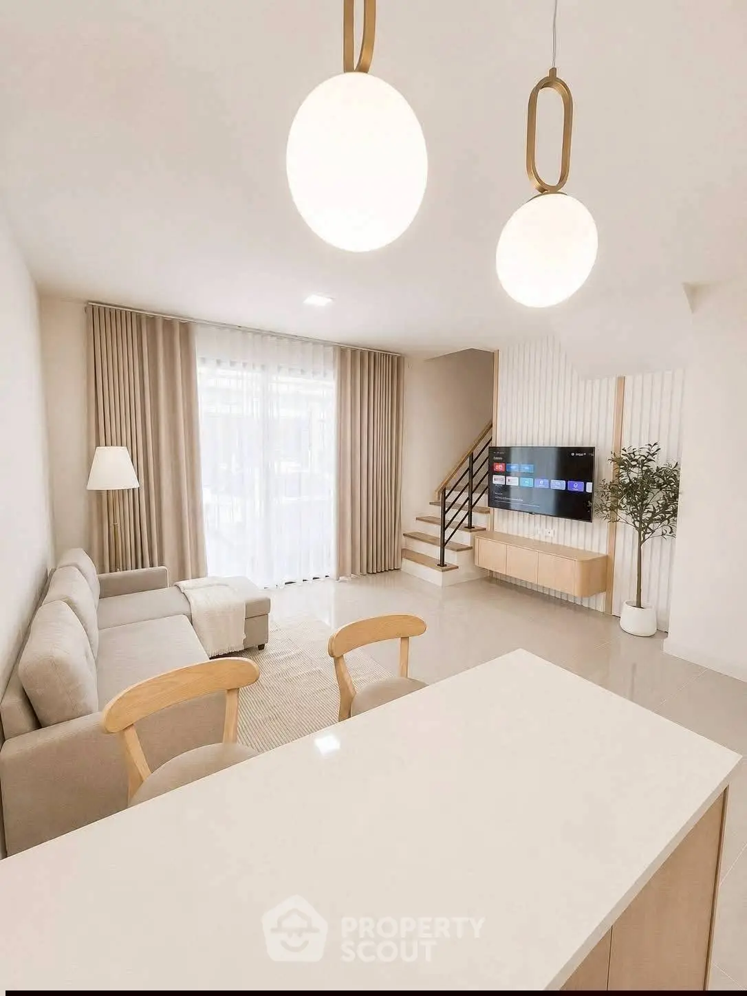 Modern living room with elegant decor, cozy seating, and stylish lighting in a bright open space.