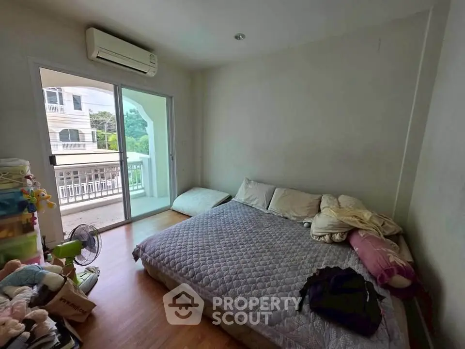 Cozy bedroom with balcony access and air conditioning in modern apartment
