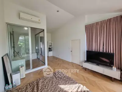 Spacious bedroom with modern decor and large windows for natural light