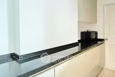 Modern kitchen with sleek black countertops and built-in microwave