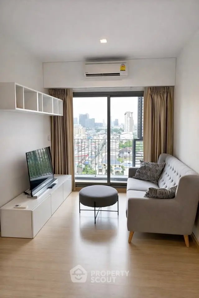 Modern living room with city view, featuring sleek furniture and large windows for natural light.