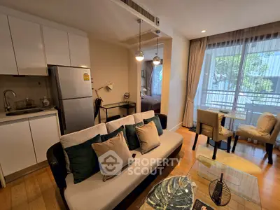Modern open-plan living room with kitchen and dining area, featuring stylish decor and natural light.