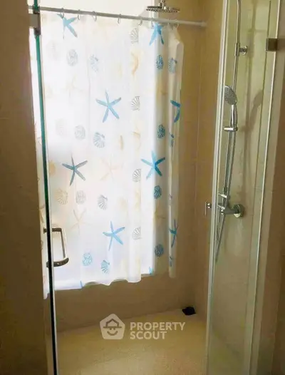 Bright bathroom with shower curtain and glass door, ideal for modern living.