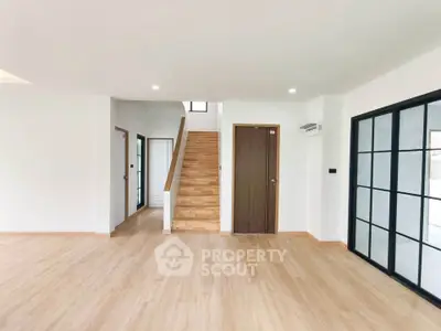 Spacious modern living room with wooden flooring and elegant staircase