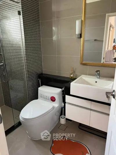 Modern bathroom with sleek fixtures and stylish design, featuring a glass shower and elegant vanity.