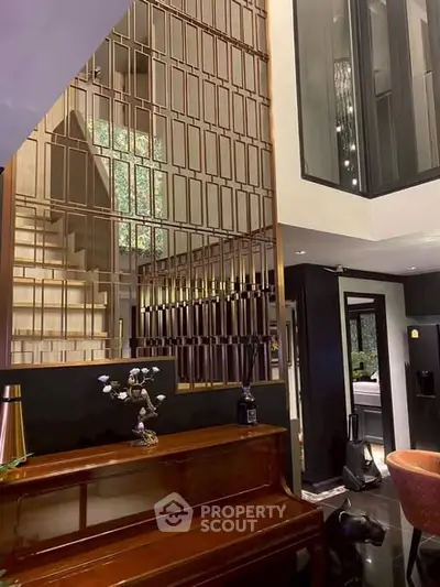 Luxurious modern living room with elegant staircase and grand piano, showcasing sophisticated interior design.