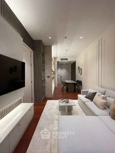 Modern living room with sleek design, cozy seating, and wall-mounted TV in a stylish apartment.