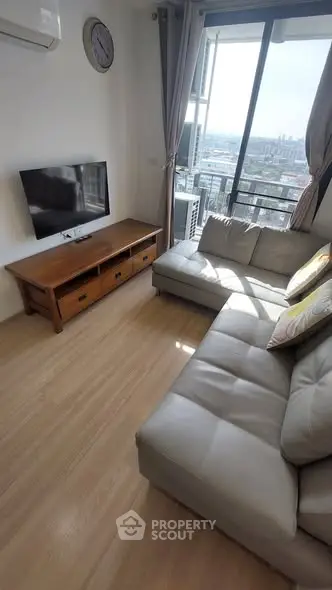 Cozy living room with modern sofa and city view from large window.
