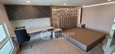 Luxurious modern bedroom with stylish decor and built-in desk, perfect for comfort and productivity.