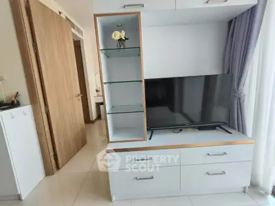 Modern living room with sleek TV unit and elegant decor in a stylish apartment.
