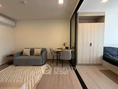 Modern living room with cozy sofa, dining area, and sliding door to bedroom in stylish apartment.