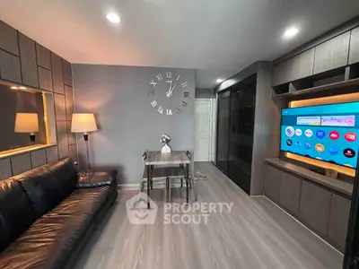 Modern living room with sleek design, featuring a large wall clock, leather sofa, and built-in entertainment unit.