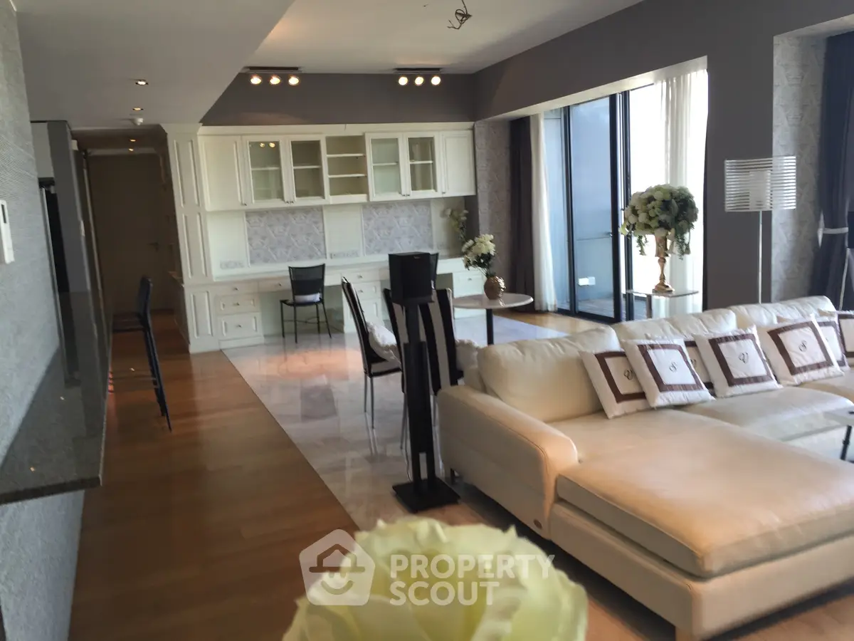 Luxurious open-plan living room with elegant decor and large windows offering natural light.