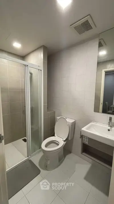 Modern bathroom with shower and sleek fixtures in a contemporary home.