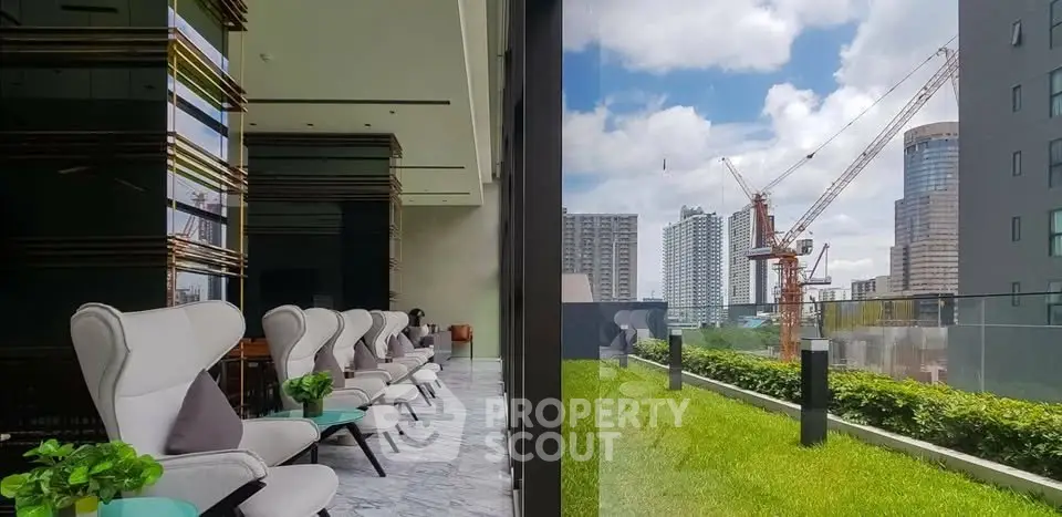 Luxurious modern lounge with panoramic city view and lush green terrace, perfect for relaxation and gatherings.