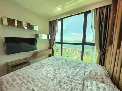 Luxurious bedroom with stunning ocean view from floor-to-ceiling windows in modern high-rise apartment.
