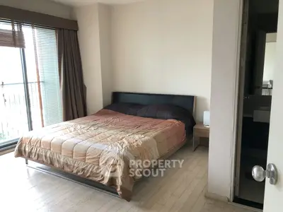 Spacious bedroom with large window and modern decor in a stylish apartment.