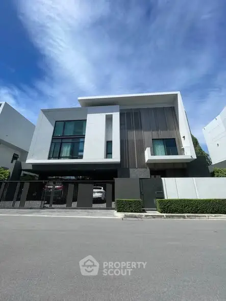 Modern luxury house exterior with sleek design and large windows under a clear blue sky.