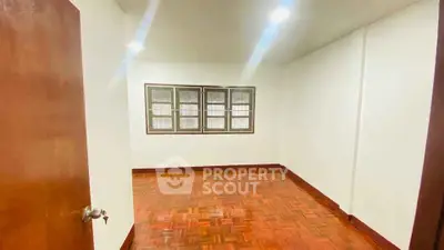 Spacious empty room with wooden flooring and bright lighting, perfect for customization.