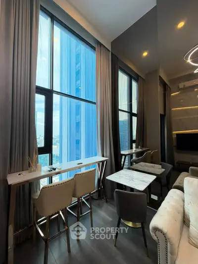 Modern living room with floor-to-ceiling windows and stylish decor in a high-rise apartment.