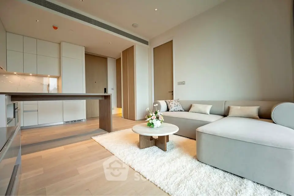 Modern living room with open kitchen, stylish furniture, and cozy ambiance.