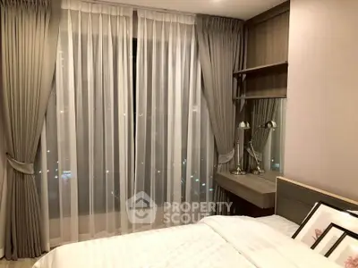 Elegant bedroom with large window and stylish curtains in modern apartment.