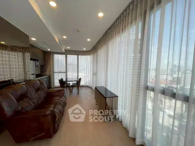 Spacious living room with panoramic city views and elegant furnishings.