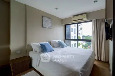 Modern bedroom with large window and air conditioning in a stylish apartment.