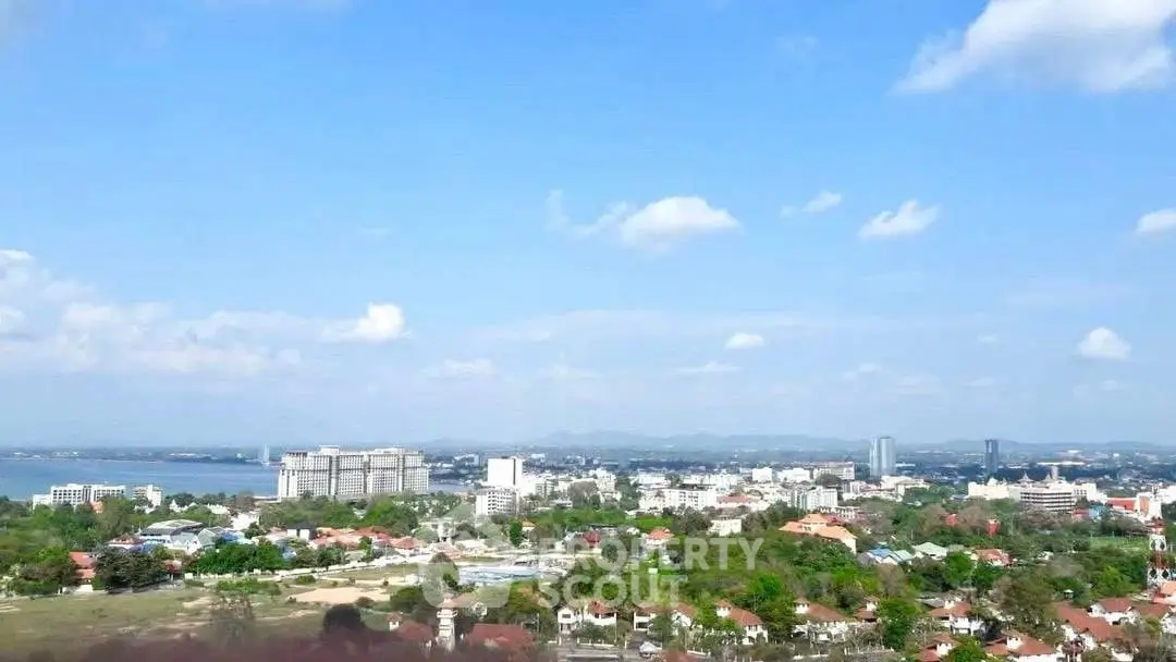 Stunning cityscape view with lush greenery and distant skyline under a clear blue sky.