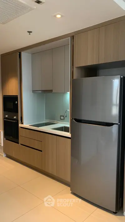 Modern kitchen with sleek cabinetry and stainless steel appliances in a contemporary apartment.