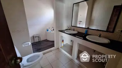 Spacious bathroom with dual sinks and modern fixtures in elegant real estate property.