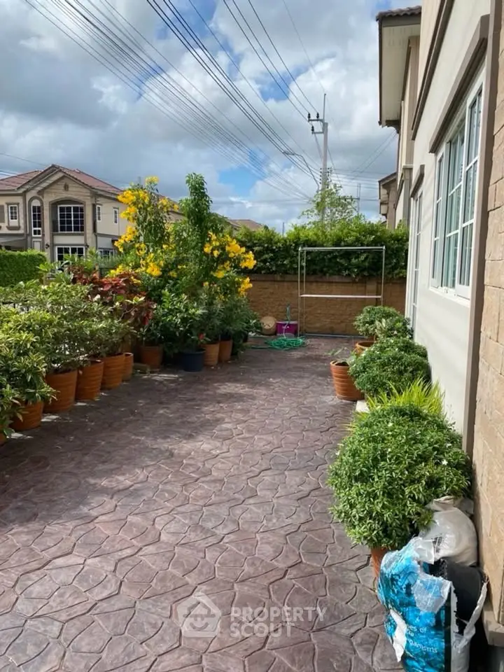 Charming garden patio with lush greenery and elegant paving in a serene residential setting.