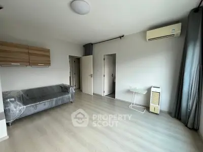 Spacious living room with modern decor and air conditioning in a bright apartment.