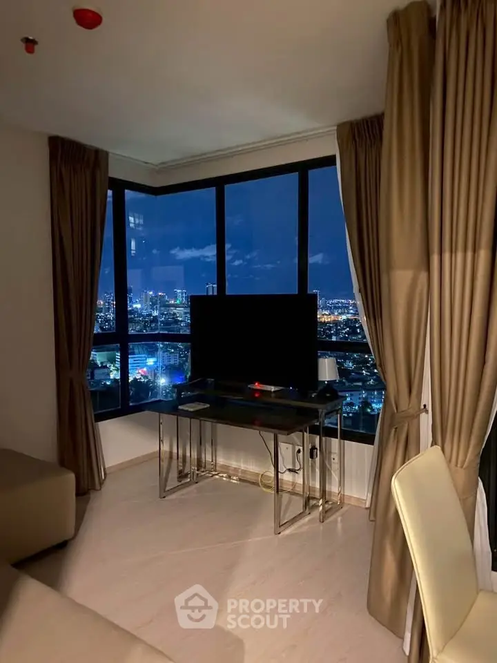 Modern living room with stunning city view through large windows at night.
