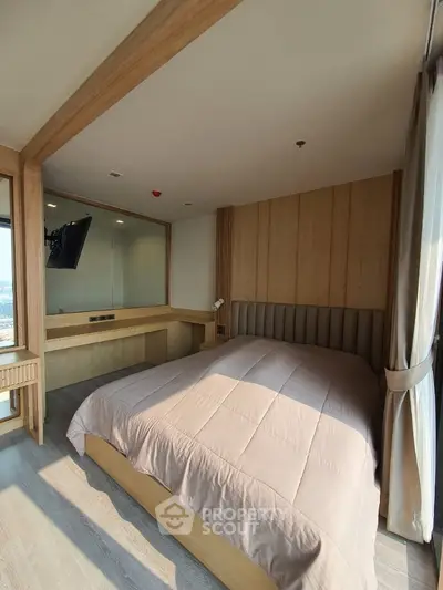 Spacious bedroom with modern wooden paneling and ample natural light, featuring a large bed, elegant furnishings, and a serene ambiance perfect for relaxation.