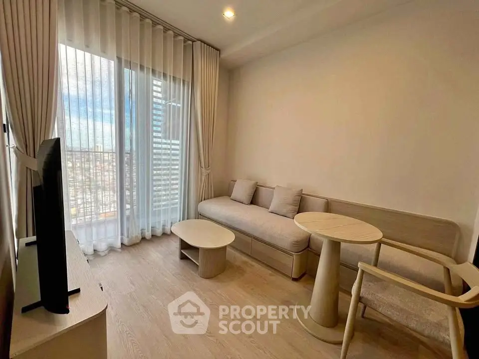Modern living room with large window and stylish furniture in a high-rise apartment.