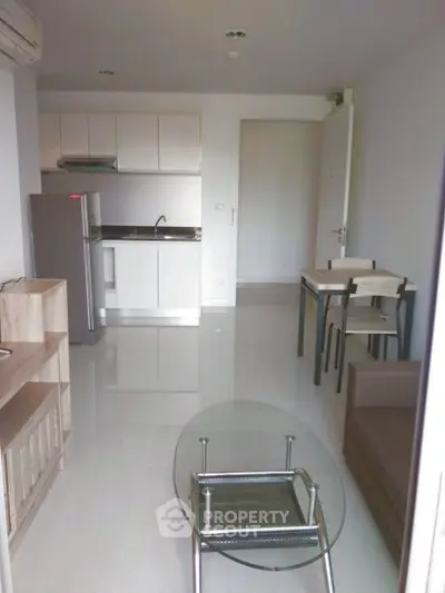 Modern open-plan living room with compact kitchen and dining area in a cozy apartment.