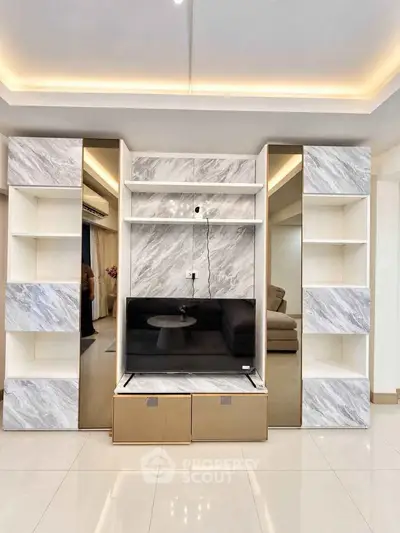 Modern living room with sleek marble shelving and built-in TV unit, showcasing elegant interior design.