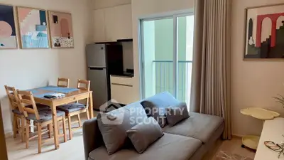 Modern living room with cozy sofa, dining area, and balcony access in stylish apartment.