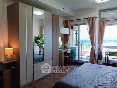 Modern bedroom with balcony and scenic view, featuring stylish decor and ample natural light.