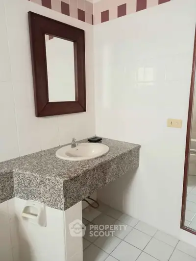 Spacious bathroom with elegant granite countertop and large mirror