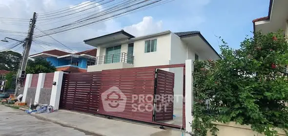 Modern two-story house with sleek wooden gate and lush greenery.